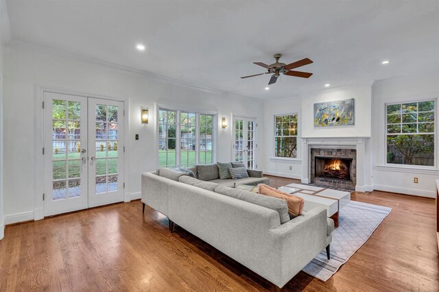 living room with wood-type flooring, ornamental molding, and a wealth of natural light