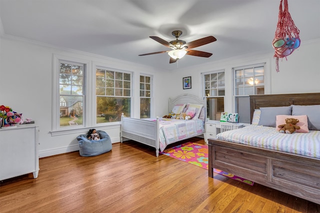 bedroom featuring ceiling fan, wood-type flooring, and ornamental molding