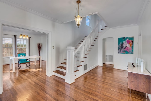 stairway with wood-type flooring and ornamental molding