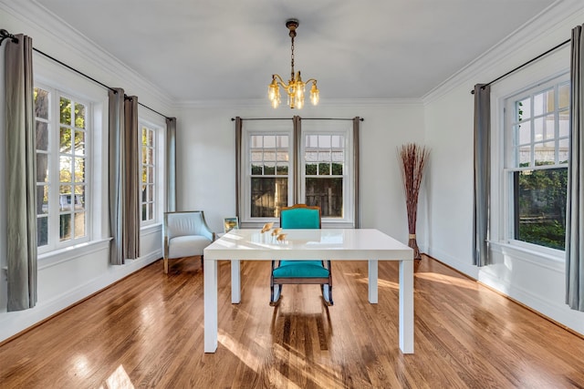 living room featuring hardwood / wood-style floors, plenty of natural light, crown molding, and a notable chandelier