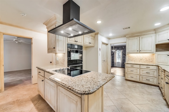 kitchen with backsplash, island exhaust hood, cream cabinets, a kitchen island, and black appliances