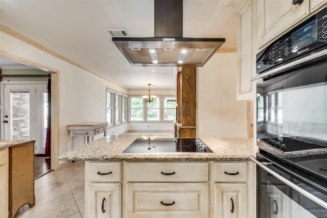 kitchen with an inviting chandelier, crown molding, island range hood, light tile patterned flooring, and black appliances