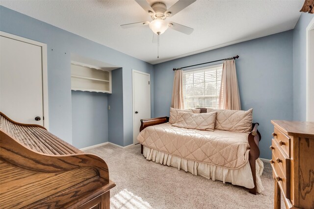 bedroom with ceiling fan, carpet floors, and a textured ceiling