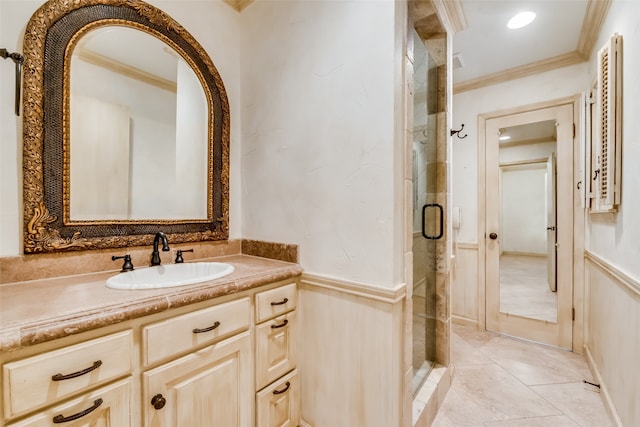 bathroom with tile patterned flooring, vanity, a shower with shower door, and ornamental molding