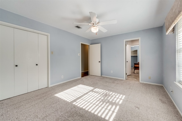 unfurnished bedroom with ceiling fan, light colored carpet, and a closet