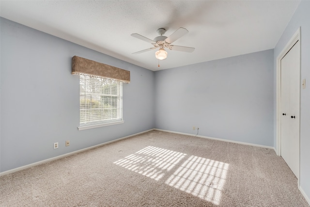 carpeted empty room featuring ceiling fan