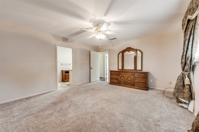 unfurnished bedroom featuring ensuite bath, ceiling fan, light colored carpet, and ornamental molding