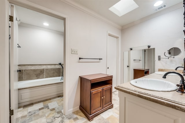 bathroom with vanity, a skylight, crown molding, and a bathing tub