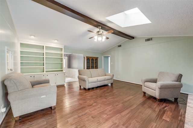 living room with ceiling fan, vaulted ceiling with skylight, and dark wood-type flooring