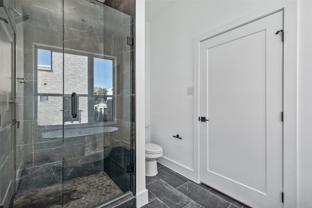 bathroom with toilet and a shower with shower door