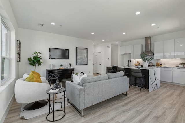 living room featuring light hardwood / wood-style floors and sink