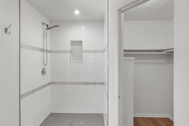 bathroom featuring a tile shower and hardwood / wood-style floors