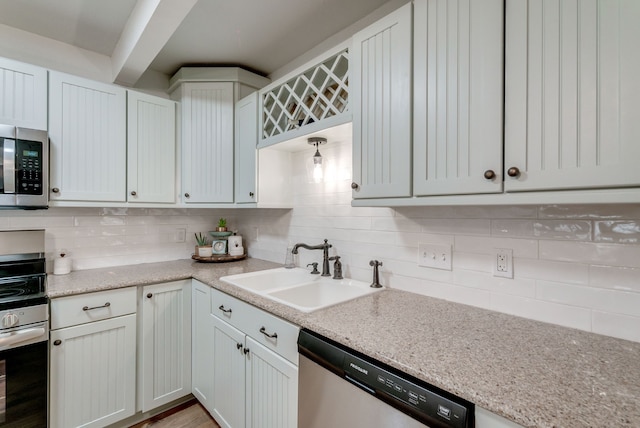 kitchen featuring backsplash, white cabinetry, sink, and stainless steel appliances