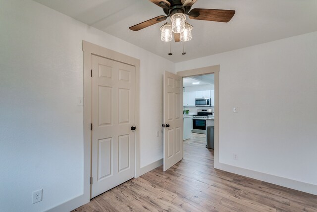 empty room featuring ceiling fan and light hardwood / wood-style flooring