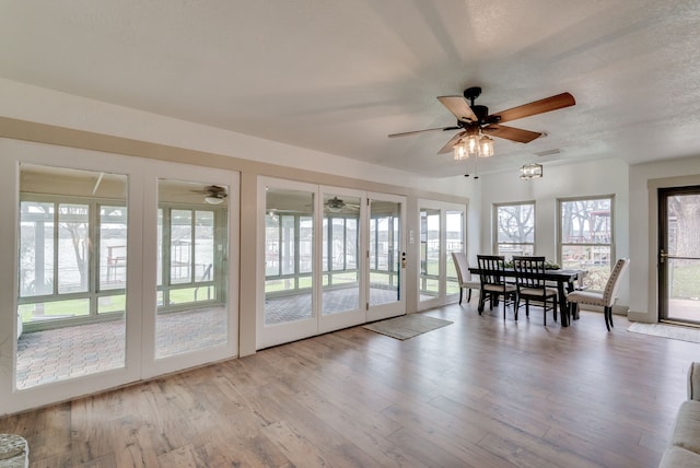 interior space with a textured ceiling, light hardwood / wood-style floors, and ceiling fan