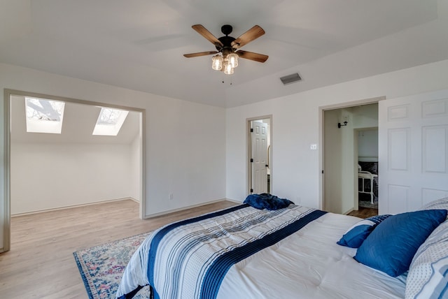 bedroom featuring ceiling fan, lofted ceiling with skylight, and light hardwood / wood-style flooring