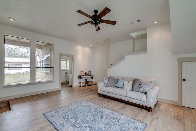 living room with ceiling fan and light hardwood / wood-style flooring