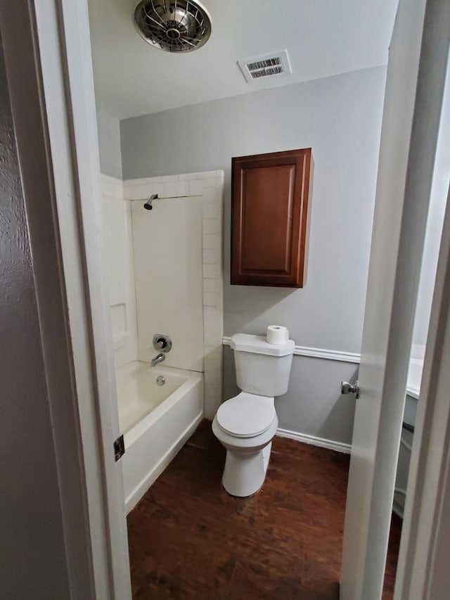 bathroom featuring shower / washtub combination, wood-type flooring, and toilet