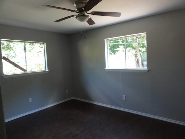 empty room with ceiling fan and dark hardwood / wood-style flooring