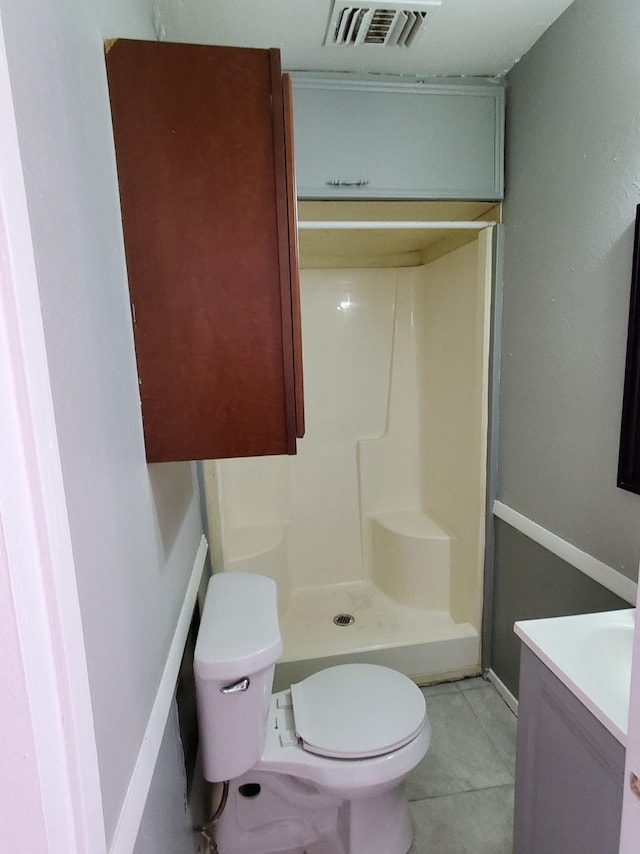 bathroom featuring toilet, tile patterned flooring, vanity, and walk in shower