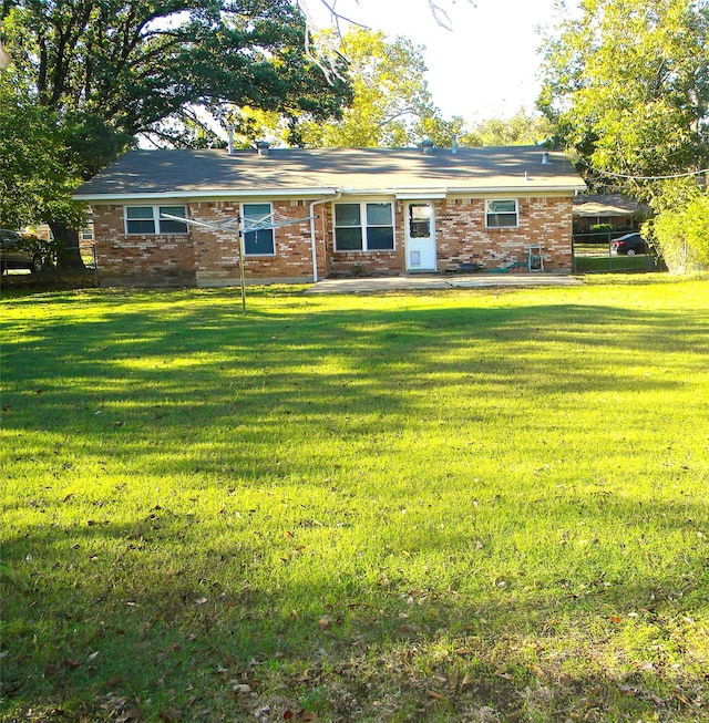 rear view of property featuring a yard