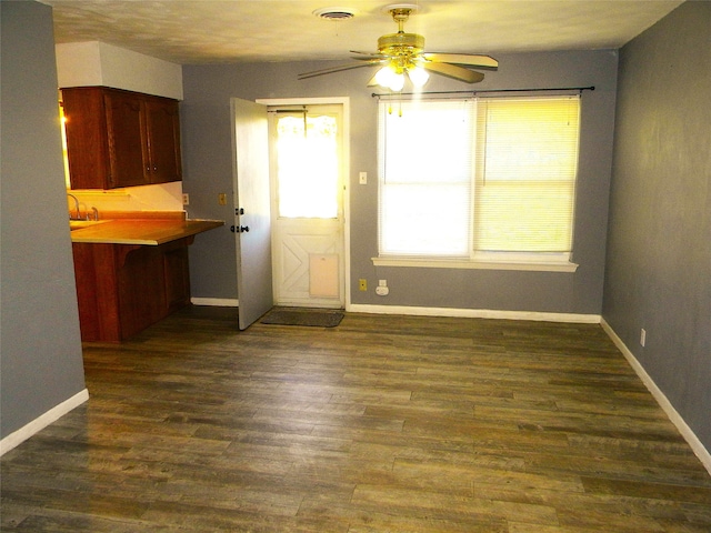 unfurnished dining area featuring dark hardwood / wood-style flooring and ceiling fan