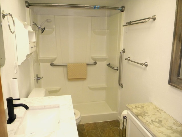 bathroom with tile patterned flooring, toilet, walk in shower, and sink