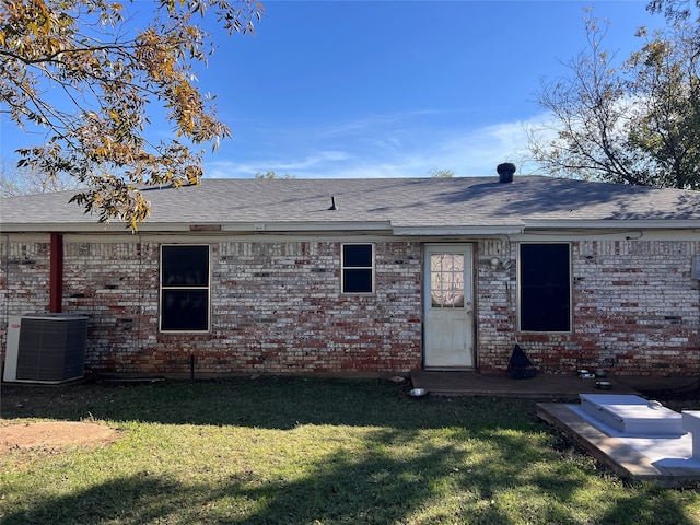 rear view of property featuring a lawn and central AC