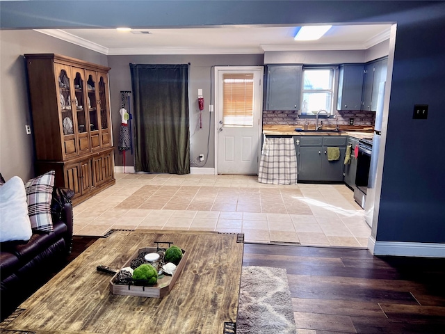 kitchen featuring baseboards, a sink, and crown molding