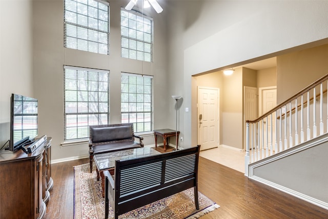 interior space featuring hardwood / wood-style floors, ceiling fan, and a high ceiling