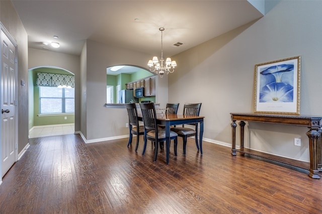 dining area featuring a notable chandelier and dark hardwood / wood-style floors