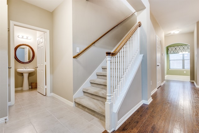 staircase with wood-type flooring and sink