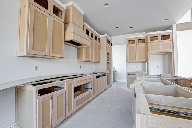 kitchen featuring light brown cabinetry and custom exhaust hood