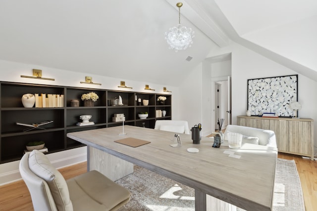 dining space featuring an inviting chandelier, radiator heating unit, light hardwood / wood-style floors, and vaulted ceiling with beams