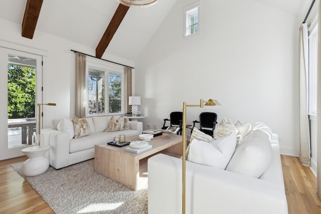 living area with high vaulted ceiling, beam ceiling, and light wood finished floors