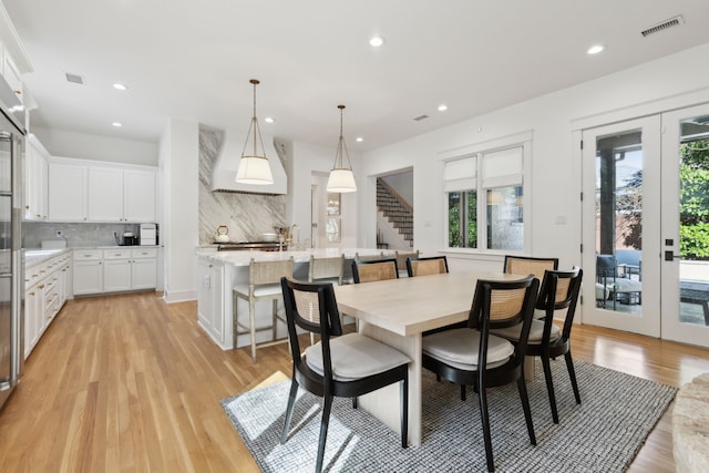 dining room with stairs, french doors, plenty of natural light, and visible vents