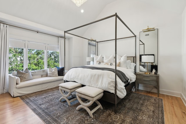 bedroom with lofted ceiling, wood finished floors, and baseboards