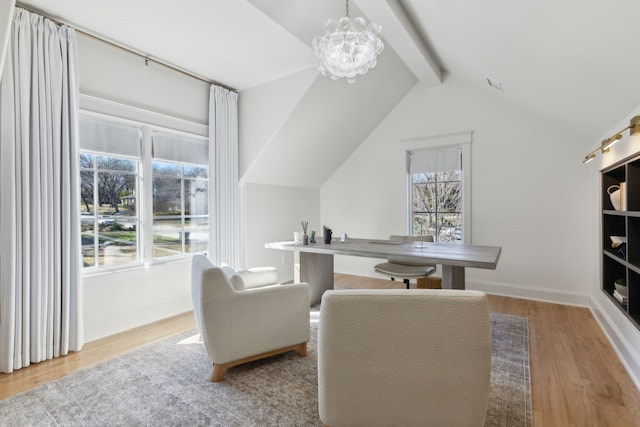 interior space featuring plenty of natural light, vaulted ceiling with beams, a chandelier, and light hardwood / wood-style floors