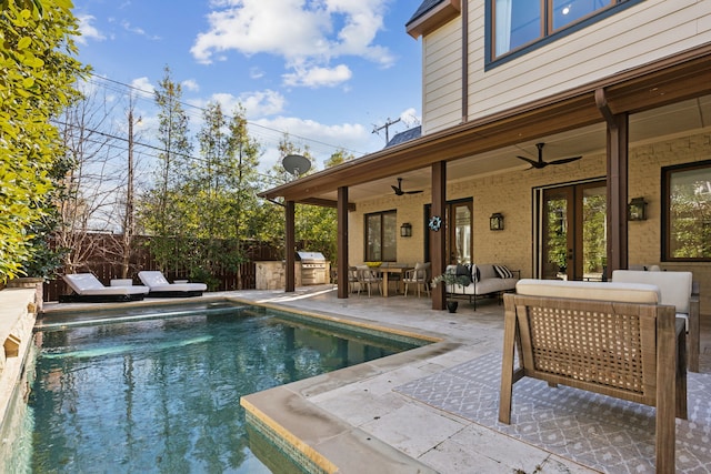 view of swimming pool with an outdoor living space, fence, an outdoor kitchen, a grill, and a patio