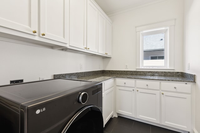 laundry area featuring washer / clothes dryer, ornamental molding, dark tile patterned flooring, and cabinets