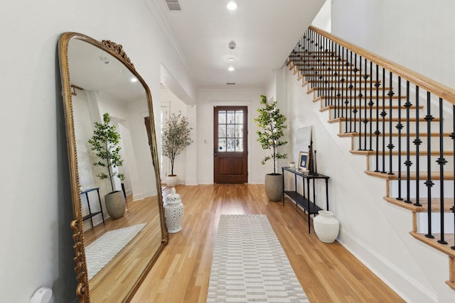 entryway featuring recessed lighting, ornamental molding, light wood-type flooring, baseboards, and stairs