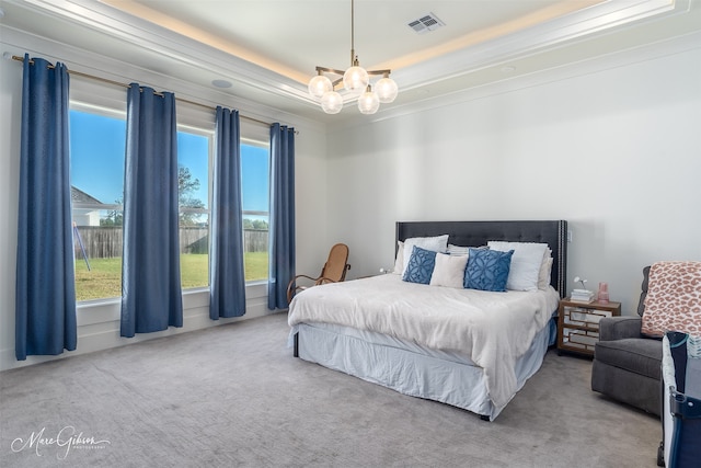 bedroom with a tray ceiling, an inviting chandelier, light colored carpet, and ornamental molding