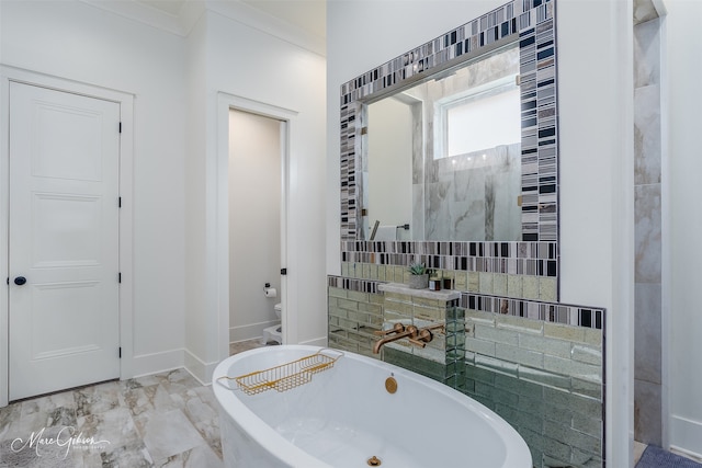 bathroom with a tub to relax in, crown molding, and toilet