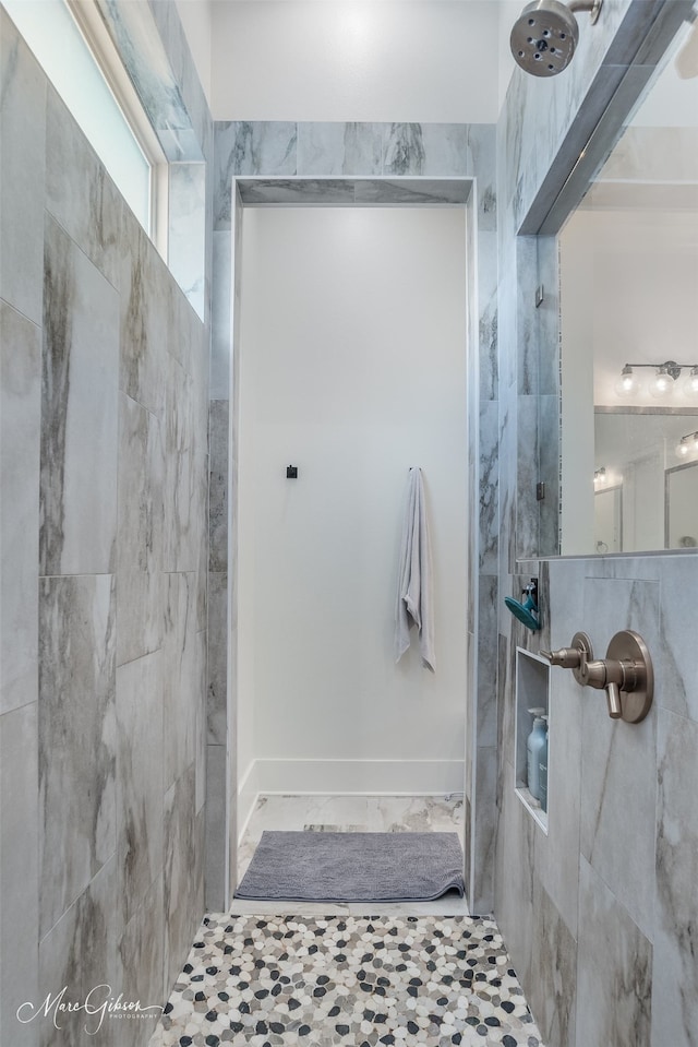 bathroom with tile patterned flooring and a tile shower