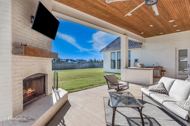 view of patio featuring an outdoor living space with a fireplace, area for grilling, and ceiling fan