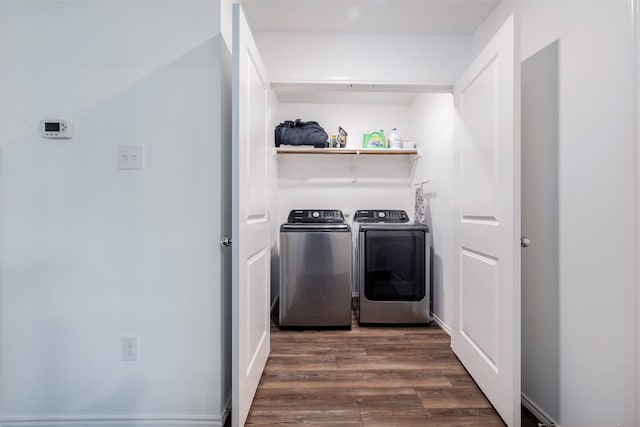 clothes washing area with separate washer and dryer and dark wood-type flooring