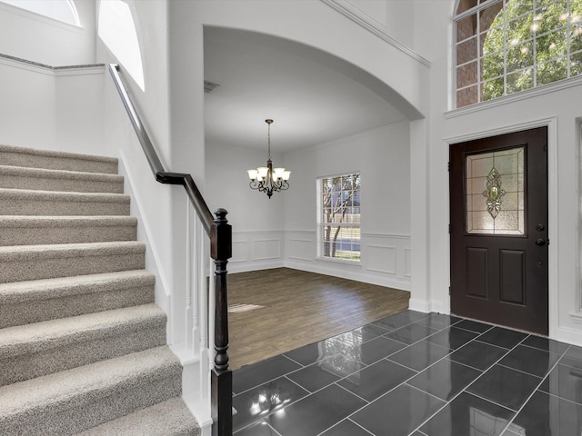 tiled foyer featuring a high ceiling and a notable chandelier