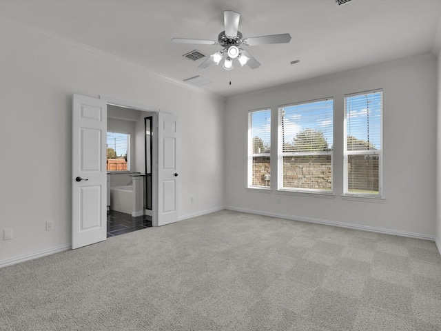 unfurnished bedroom featuring carpet flooring, ceiling fan, ensuite bathroom, and multiple windows