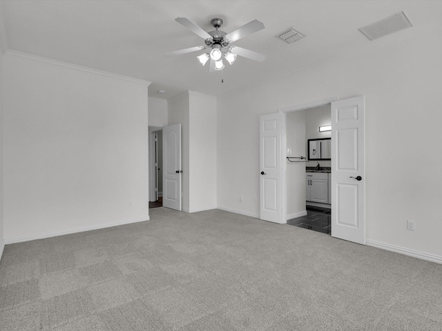 unfurnished bedroom with carpet, ceiling fan, crown molding, and ensuite bath