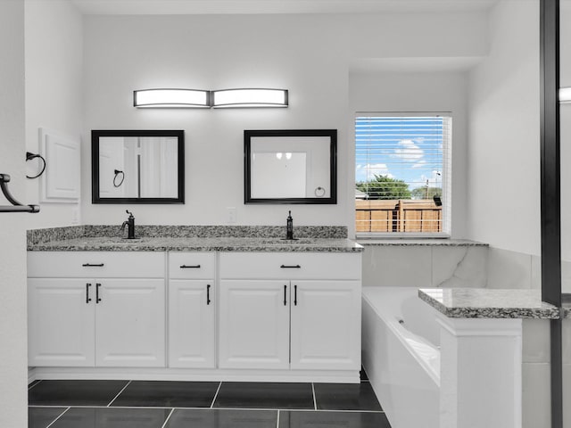 bathroom featuring tile patterned flooring, vanity, and a bath